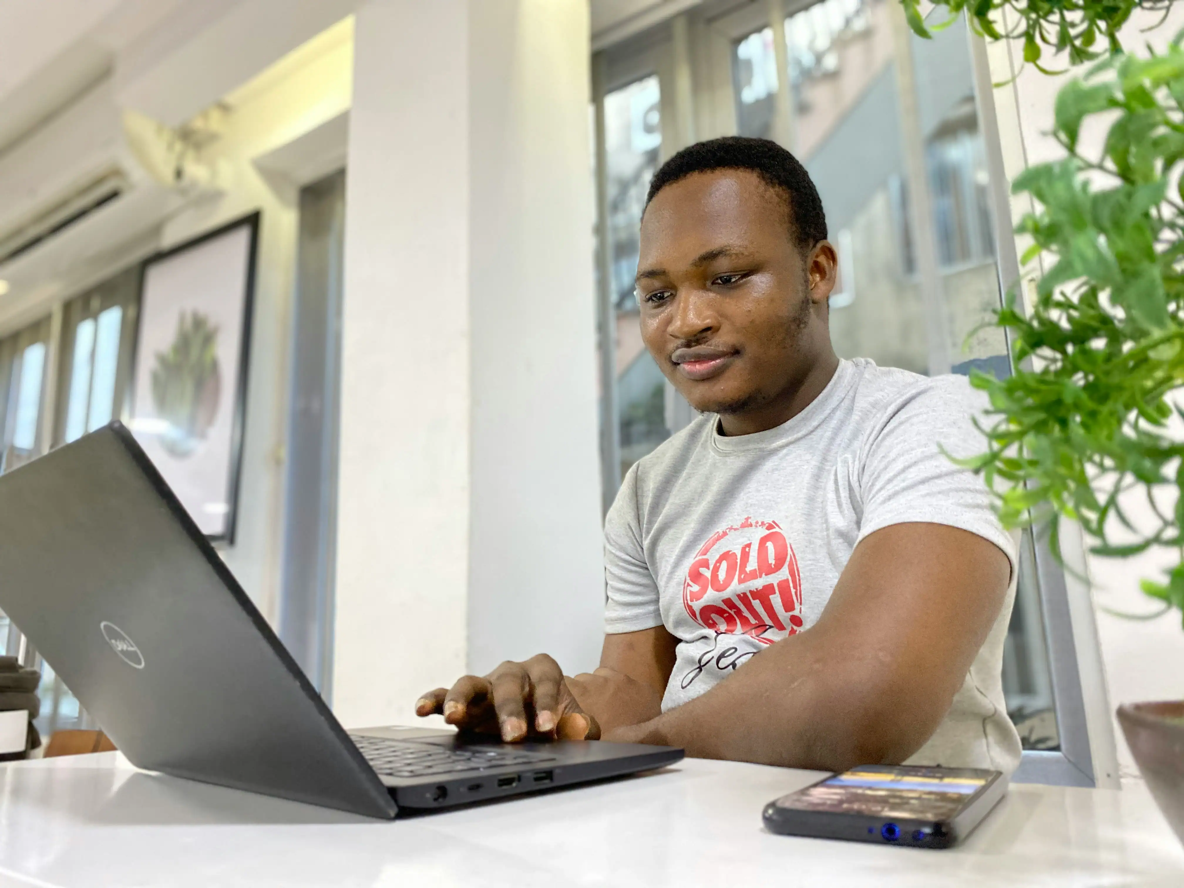 Person seated with an open laptop in front of him